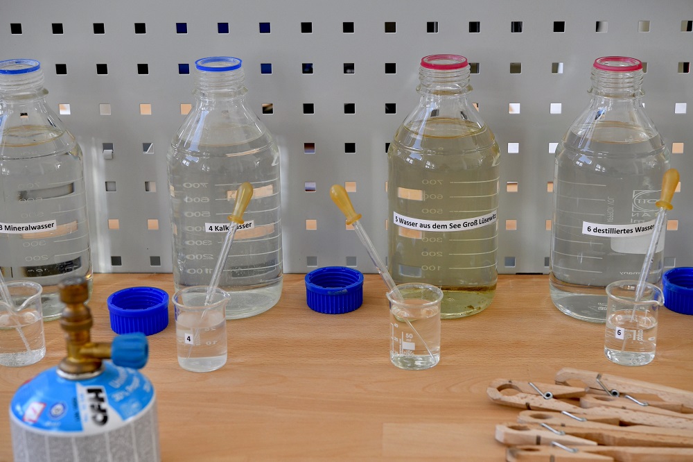 Tisch mit 4 verschiedenen Wasserproben in Glasgefäßen sowie verschiedenes Material zur Untersuchung der Proben © WKM MV I Angelika Heim Tisch mit 4 verschiedenen Wasserproben in Glasgefäßen sowie verschiedenes Material zur Untersuchung der Proben